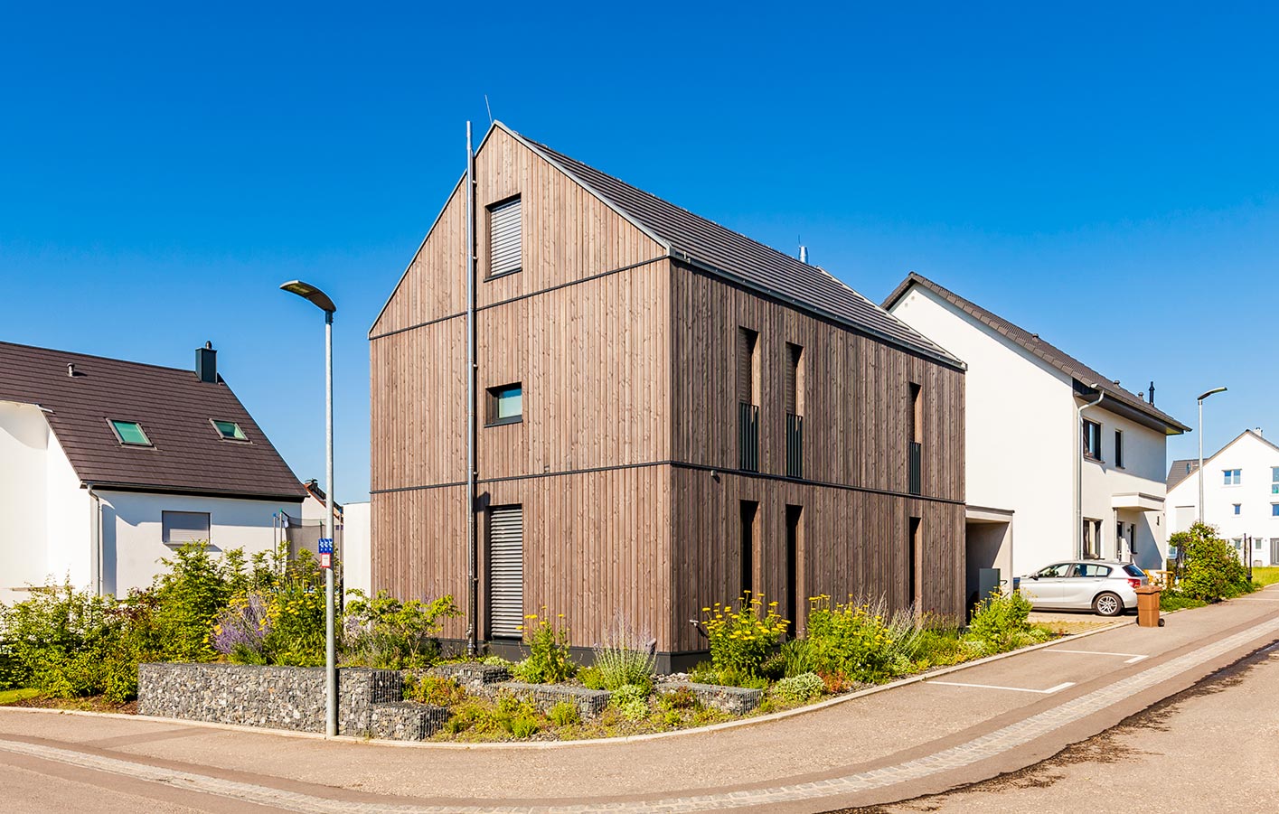 Moderne Fassadengestaltung mit Holzfür das Einfamilienhaus modernes Haus in einer Wohnsiedlung mit einer Holzfassade